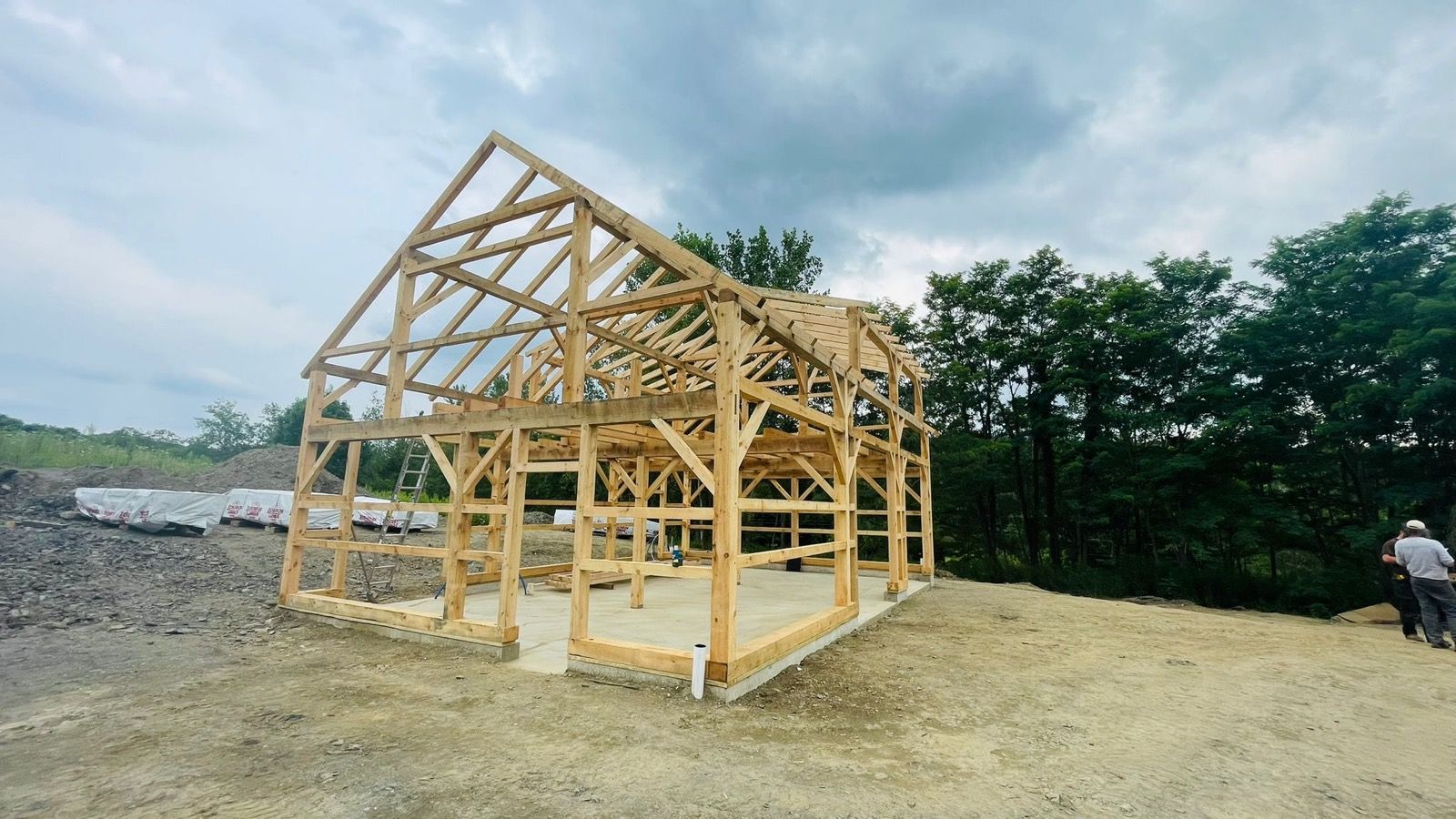 A post-and-beam barn by DA Home Improvement at the timber-frame stage, before siding.
