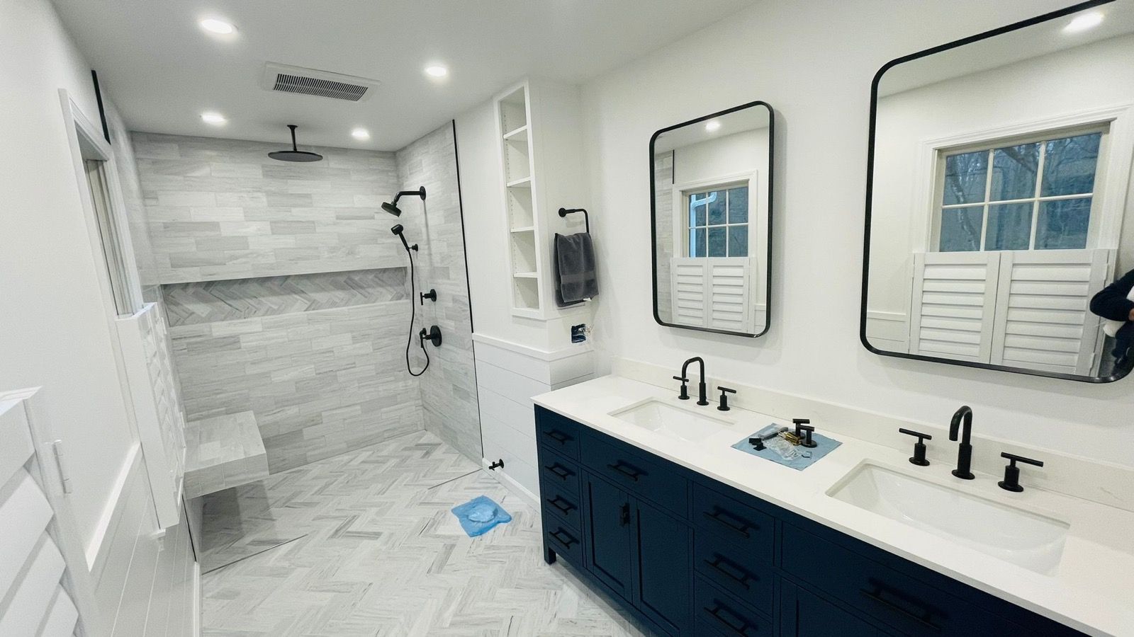 Marble-tiled bathroom with a double vanity and walk-in shower.