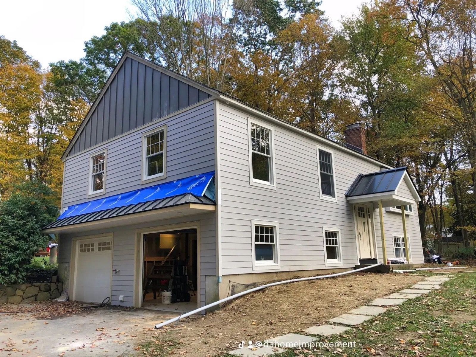 White farmhouse exterior with a standing-seam metal roof.