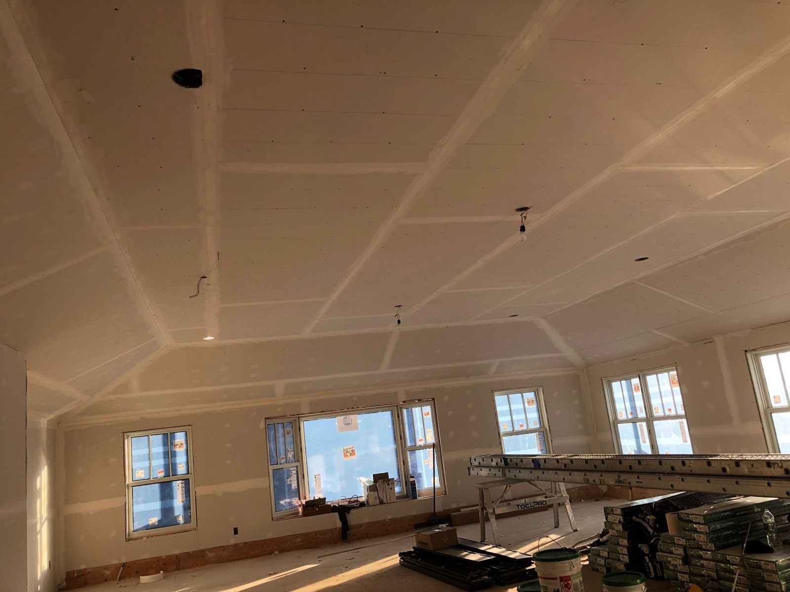 Hardwood flooring being installed in a bright interior.