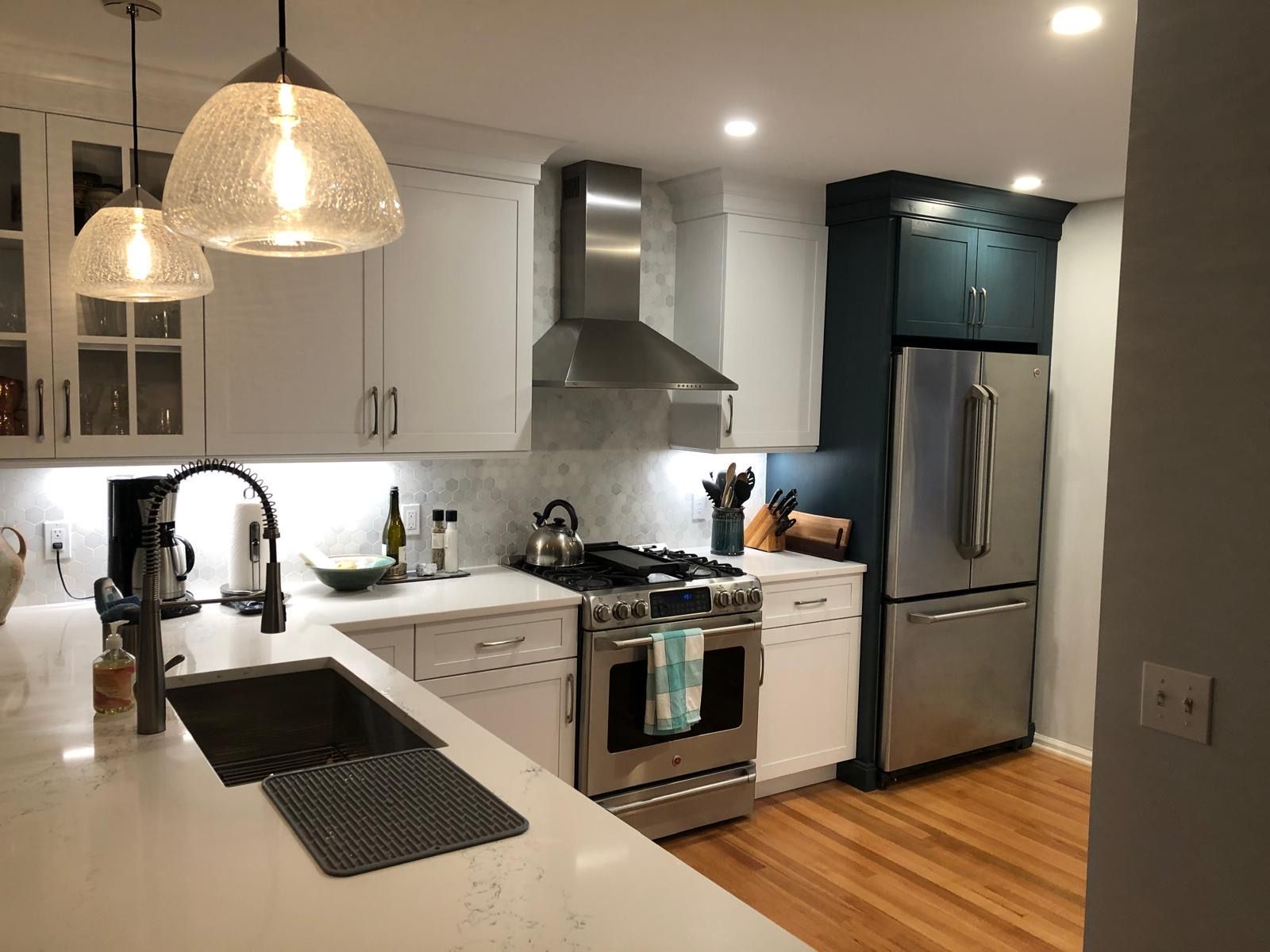 Finished kitchen with hardwood floors and pendant lighting.