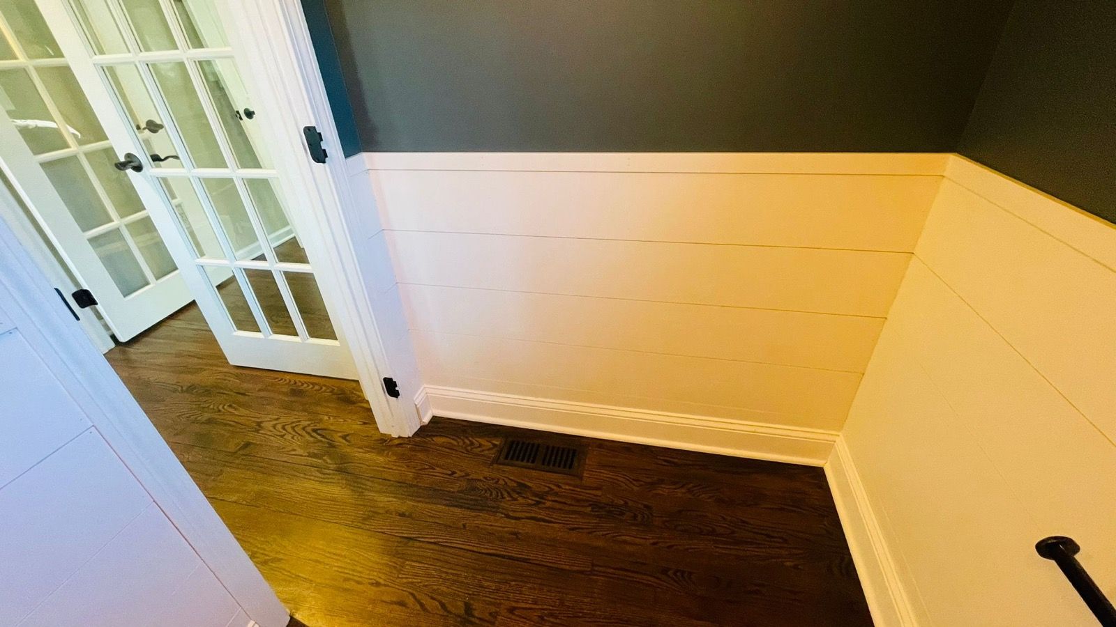 Freshly painted room with a deep navy accent and French doors.
