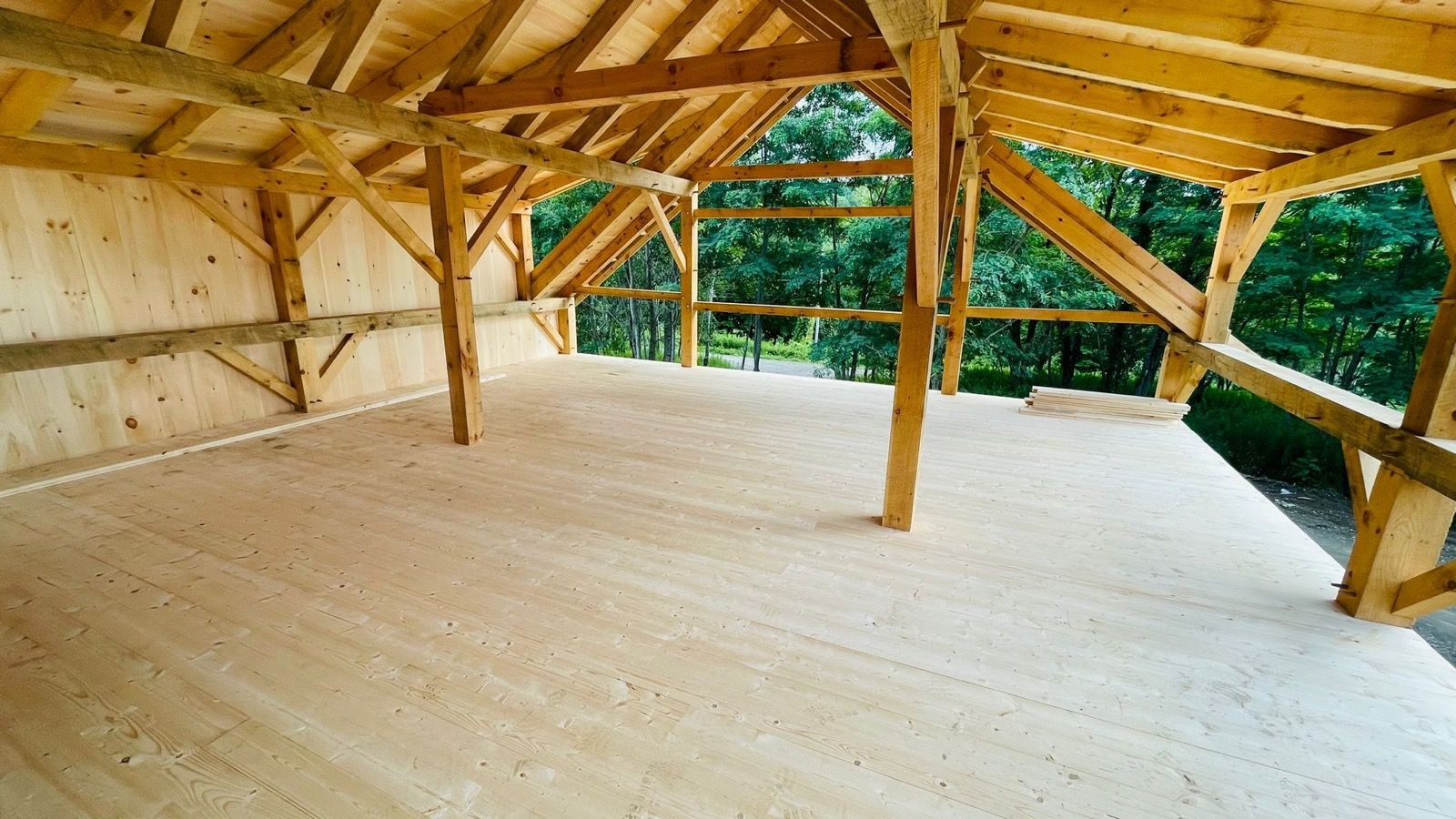 Interior of a finished timber-frame pavilion built by DA Home Improvement, exposed post-and-beam ceiling.